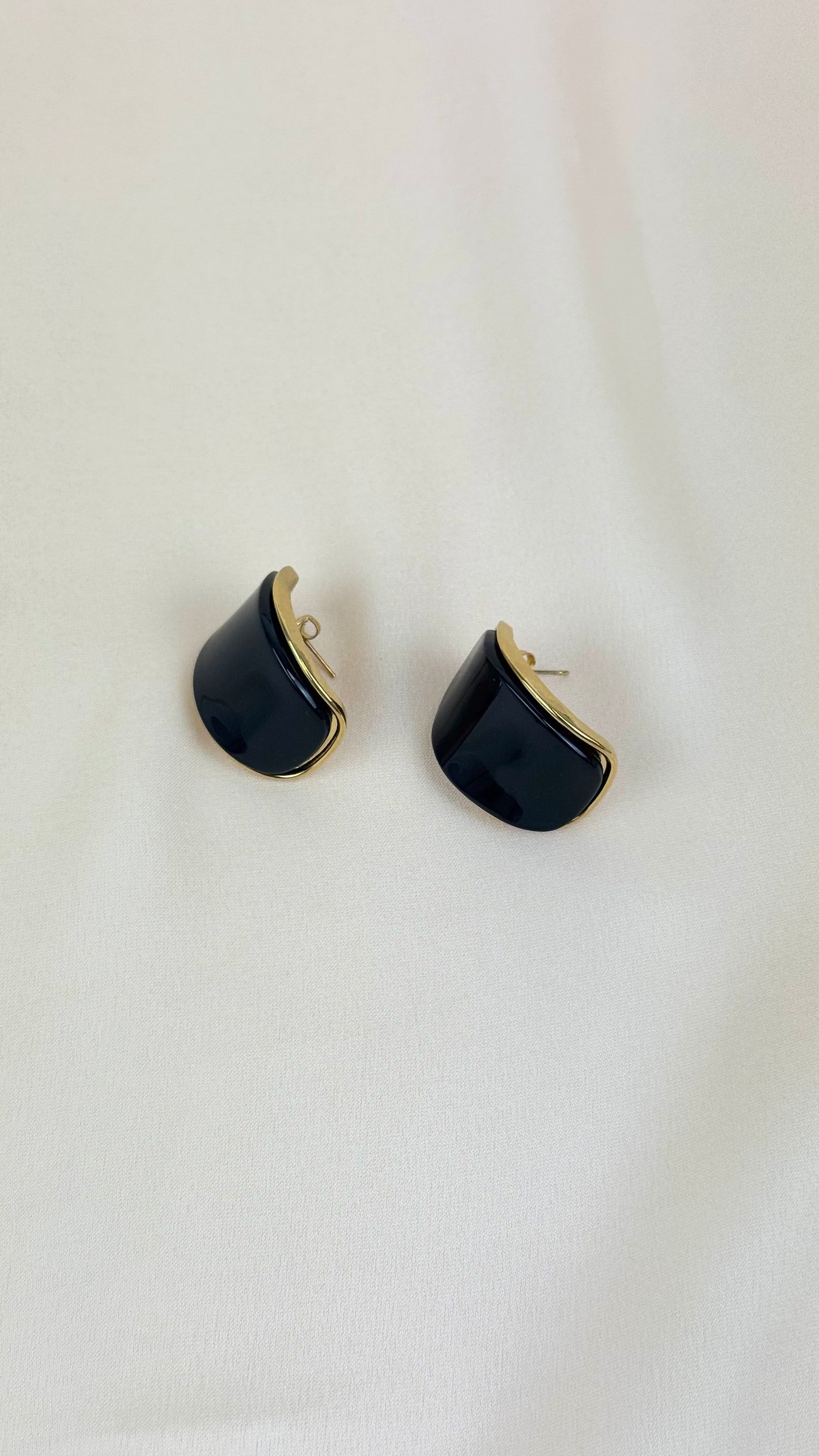 Brincos arredondados preto com rebordo aço dourado