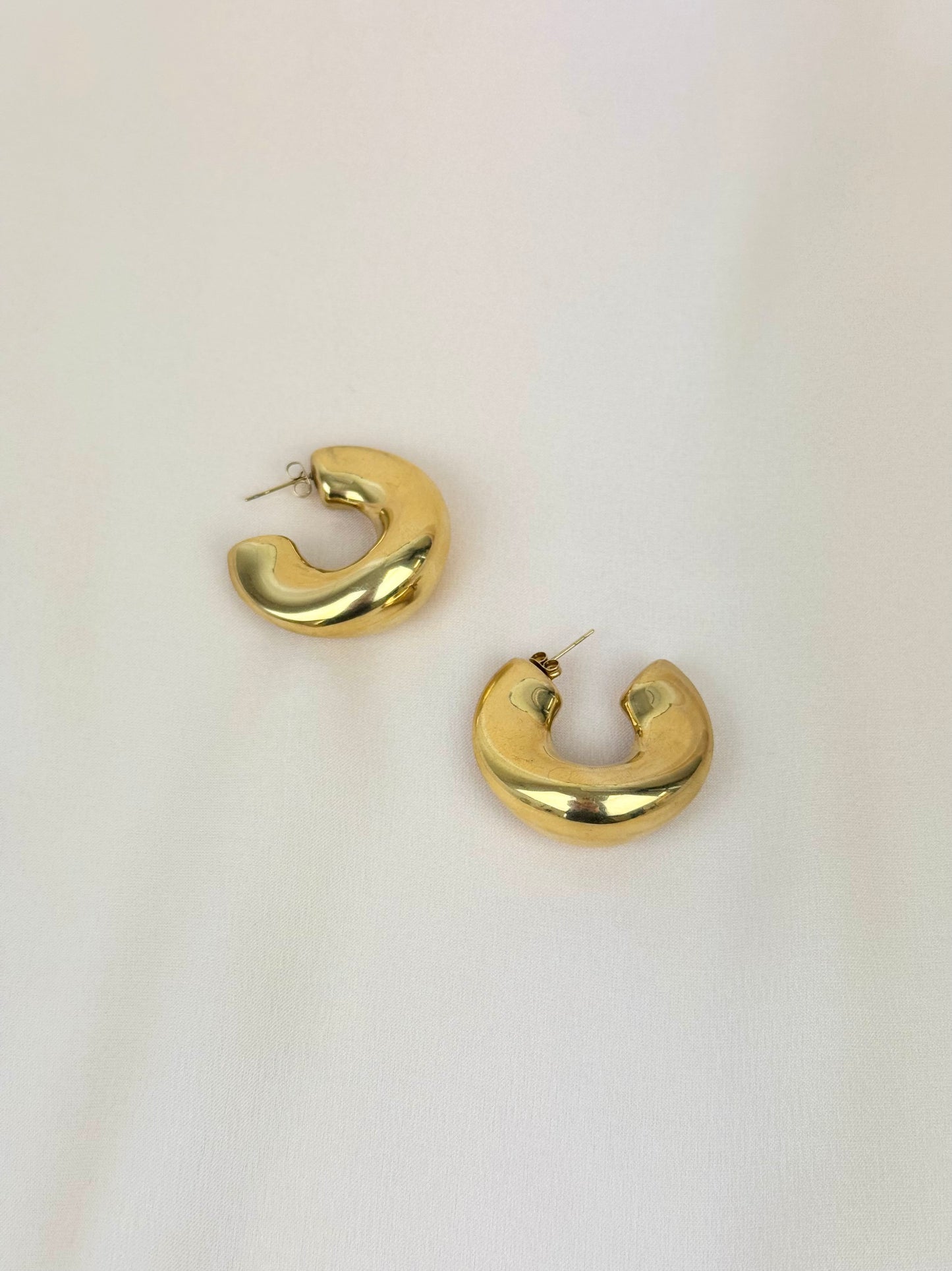 Argolas assimétricas em aço dourado