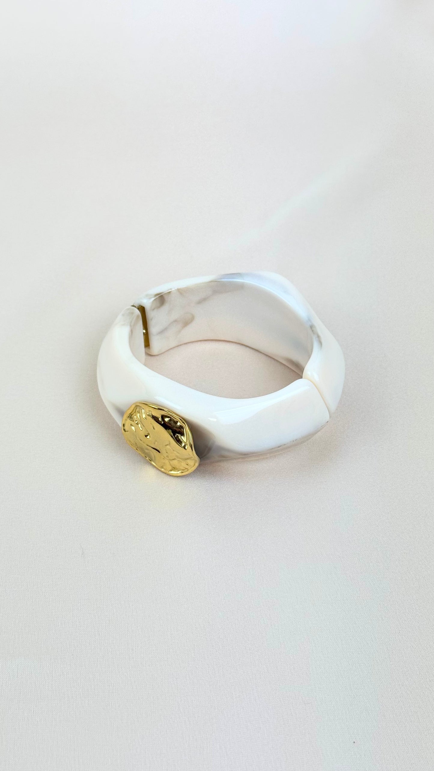 Pulseira acrílico pérola com chapa dourada