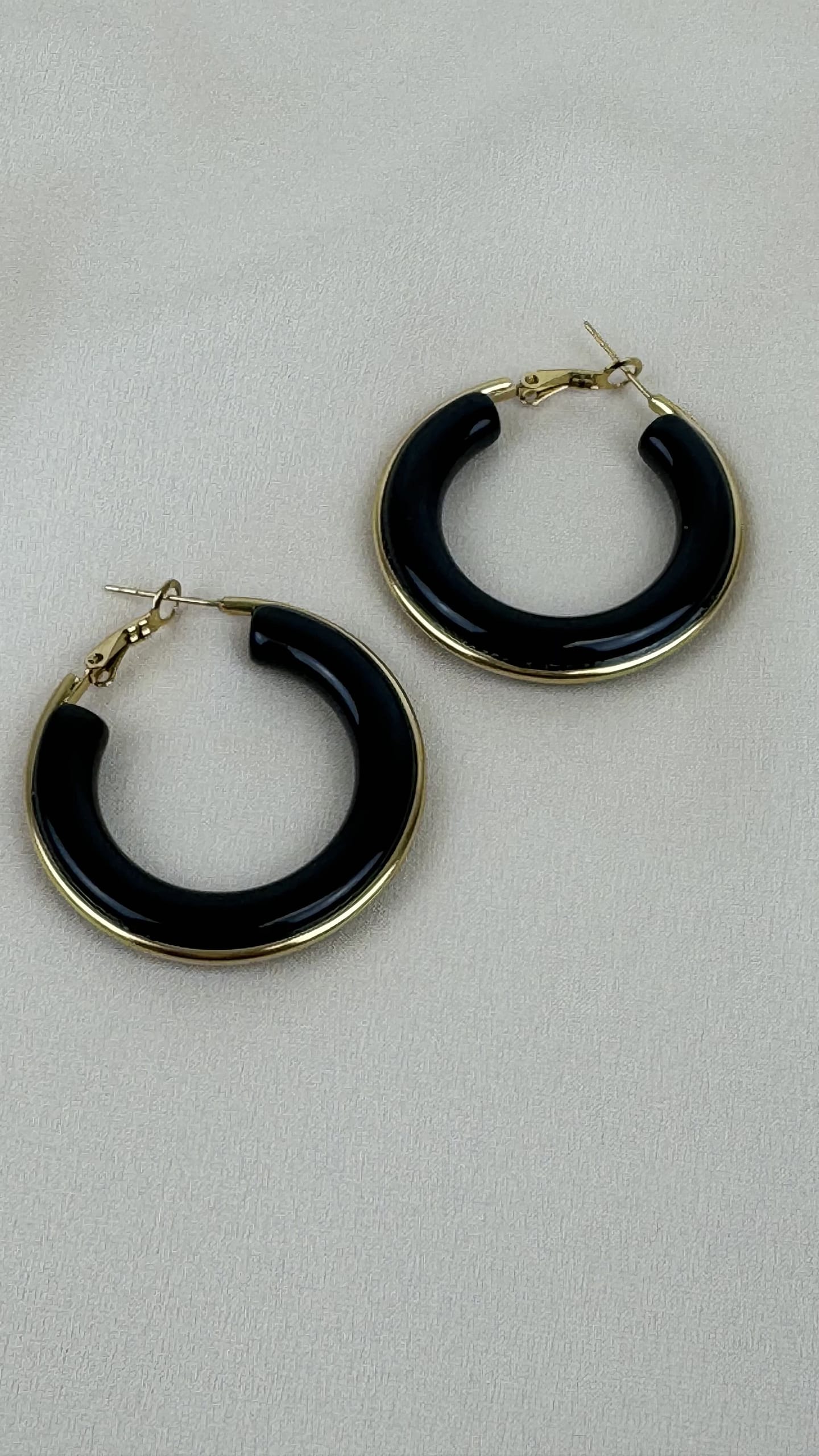 Brincos argolas acrílico preto e aço dourado