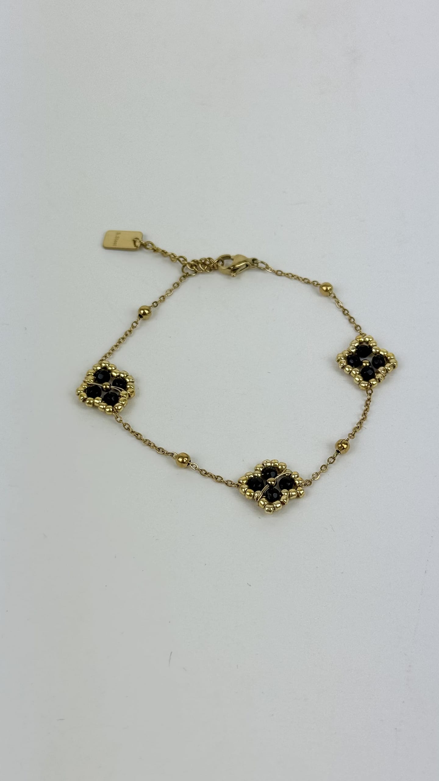 Pulseira aço dourado florzinhas preto