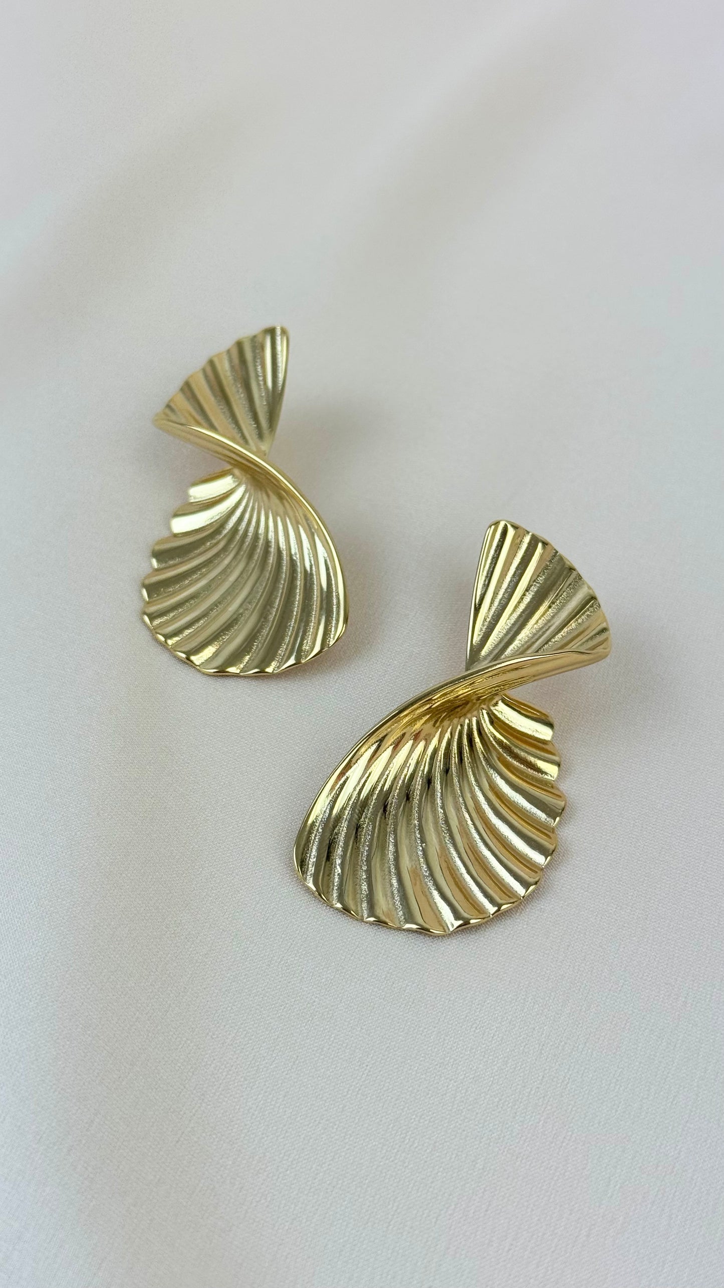 Brincos geométricos torcidos dourados aço