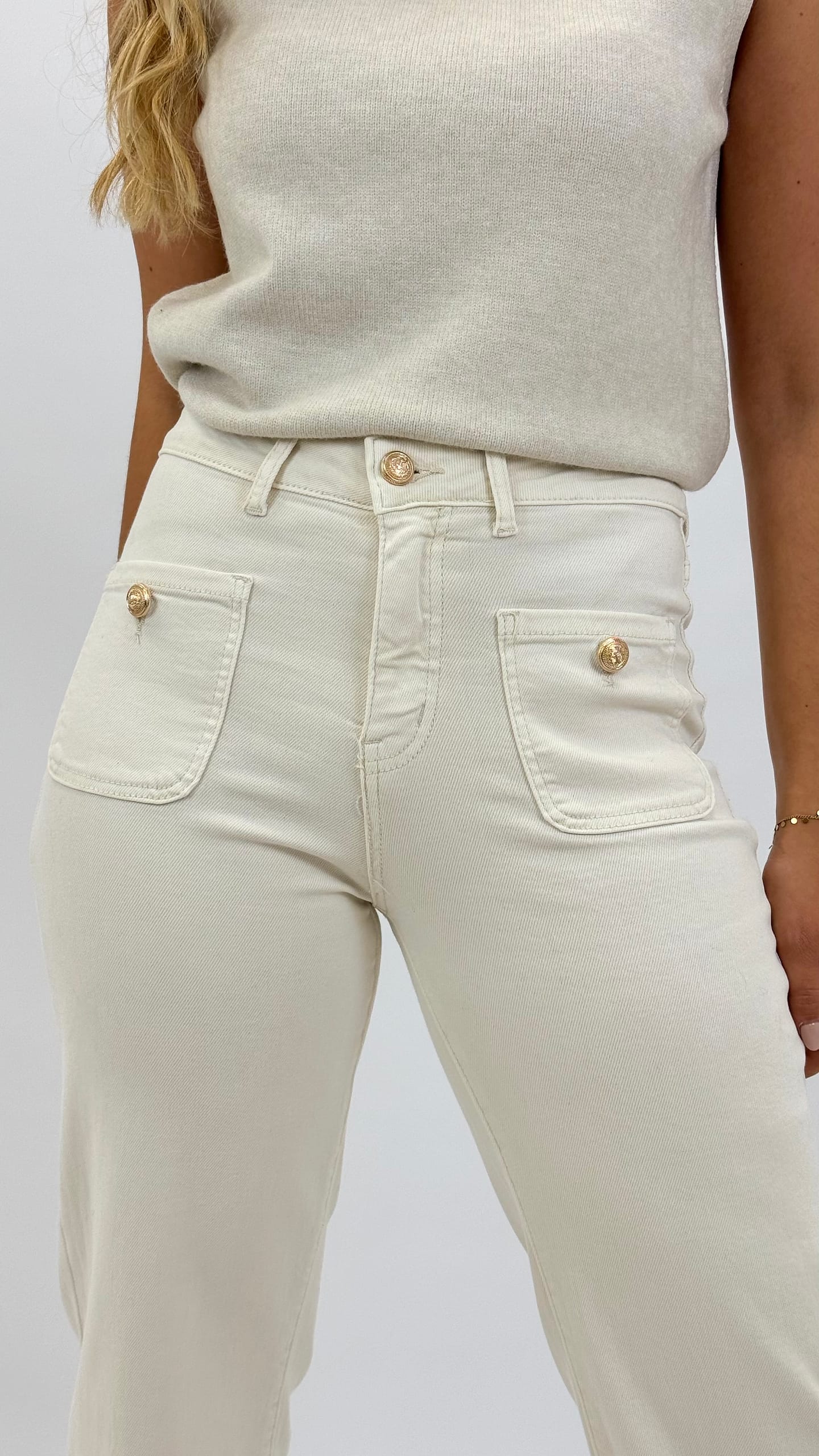 Calça com bolsos na frente e botões dourados creme