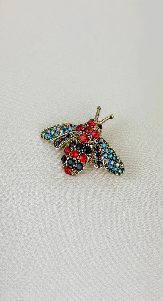 Alfinete mosca vermelho e azul