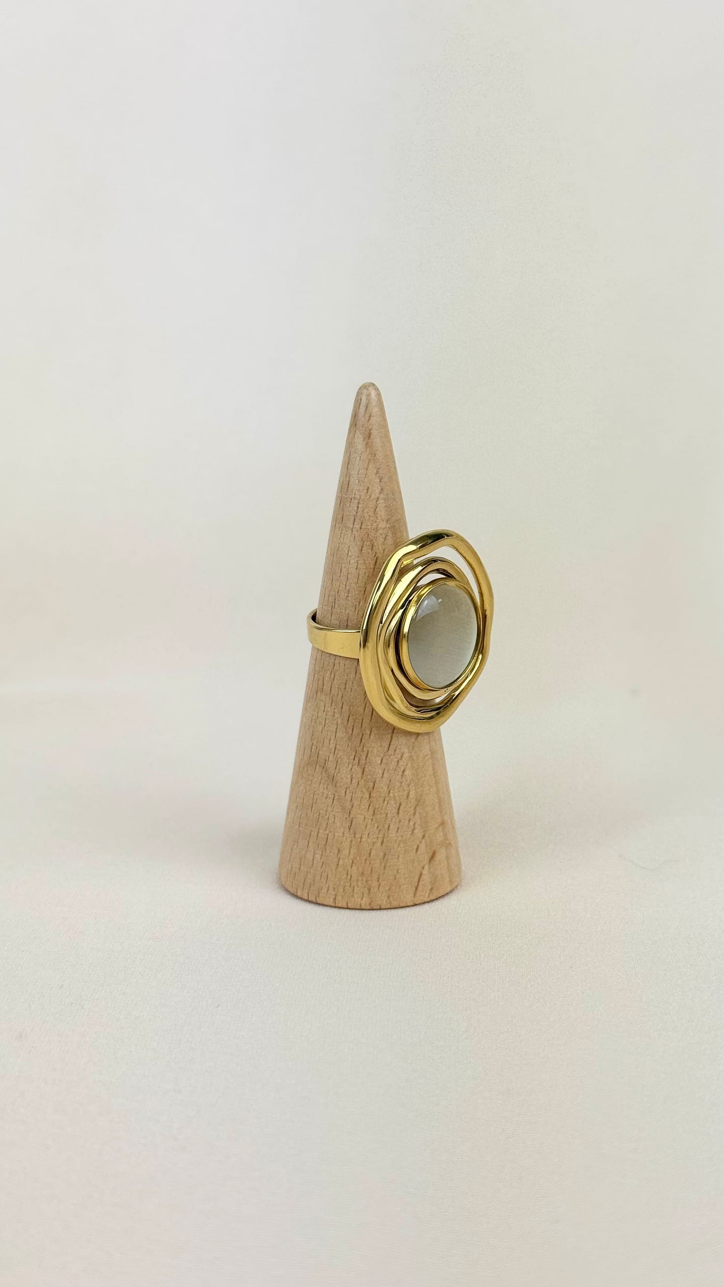 Anel aço dourado redondo com pedra bege