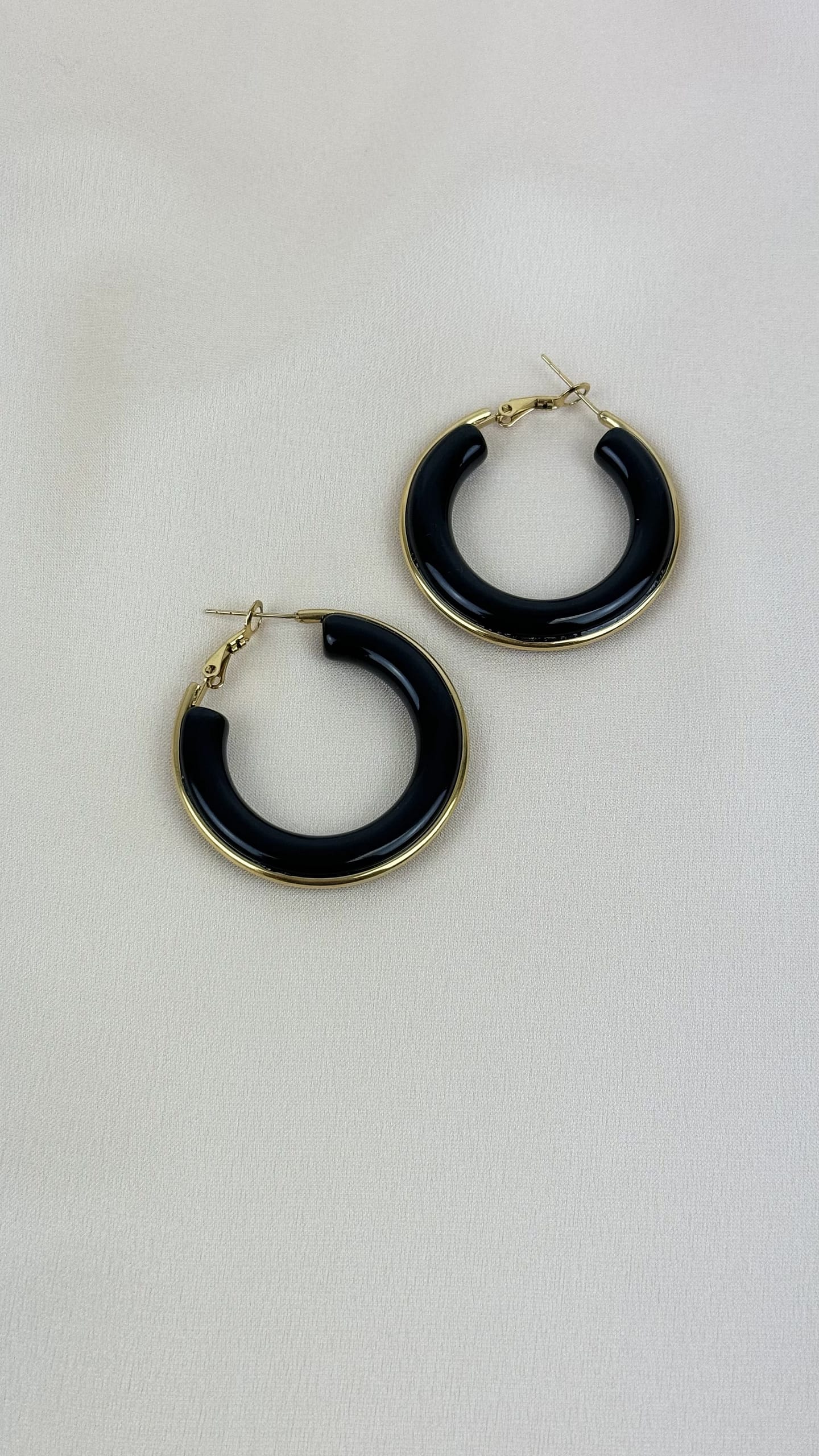 Brincos argolas acrílico preto e aço dourado