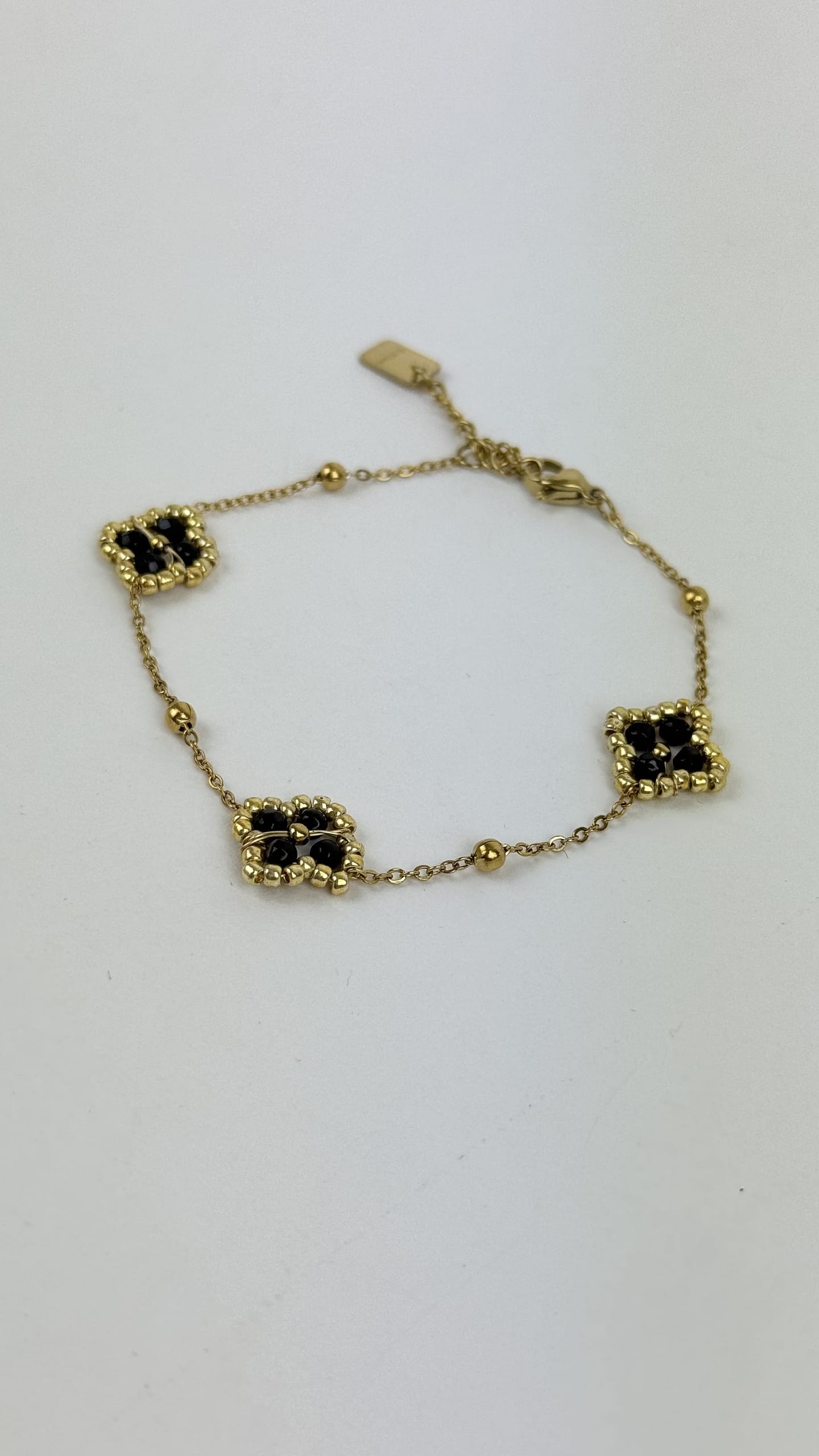 Pulseira aço dourado florzinhas preto