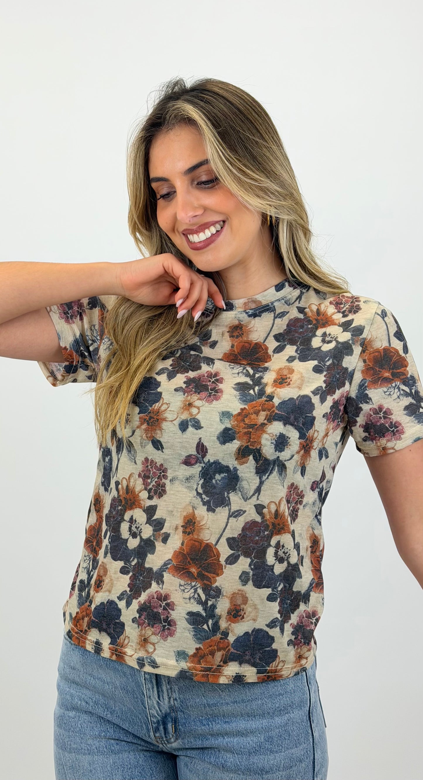 T-shirt fundo bege com padrão floral tons telha e azul