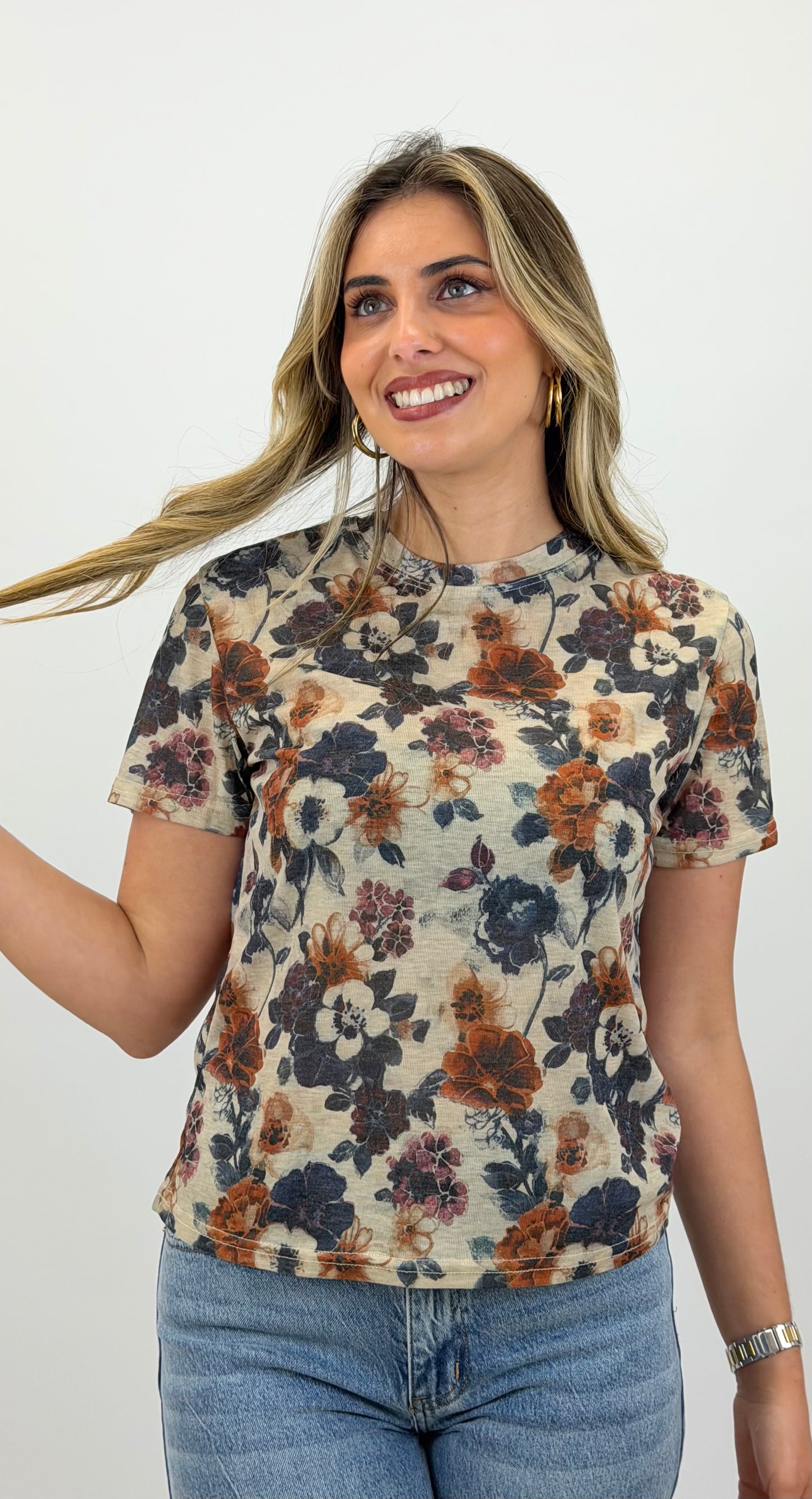 T-shirt fundo bege com padrão floral tons telha e azul