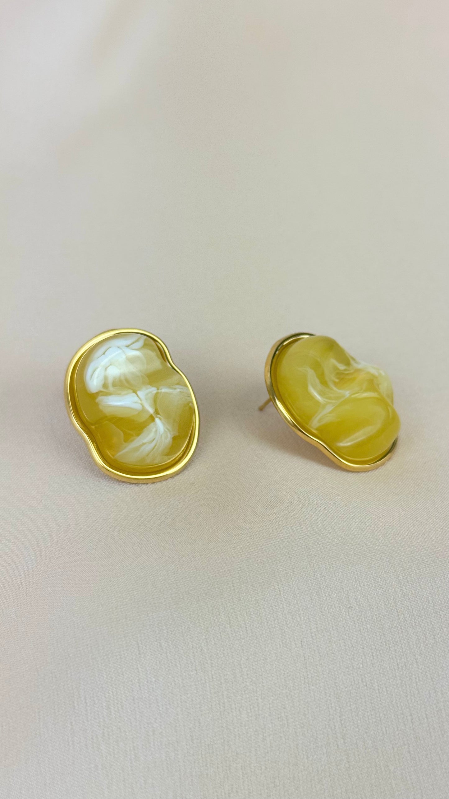 Brincos dourados com pedra amarela assimétrica