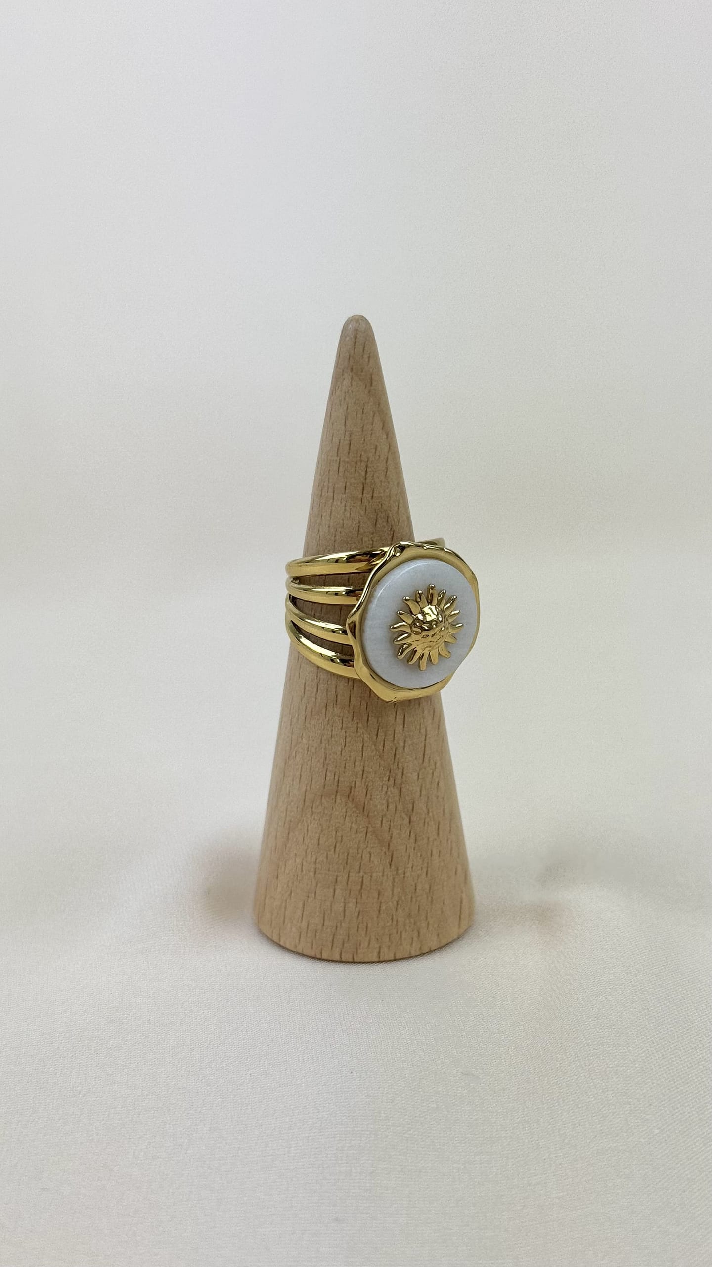 Anel aço dourado e pedra branca com roseta