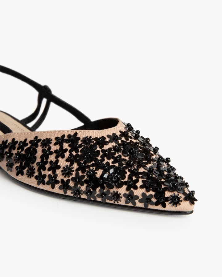 Sapato raso bege e preto com aplicações florais