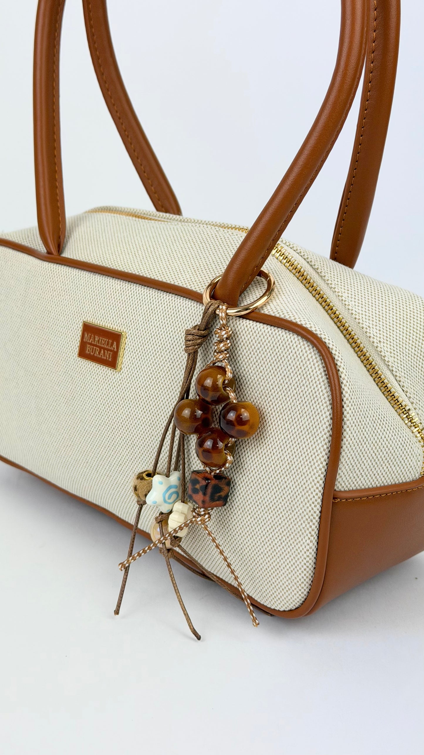 Mala rectângular bege com detalhes camel