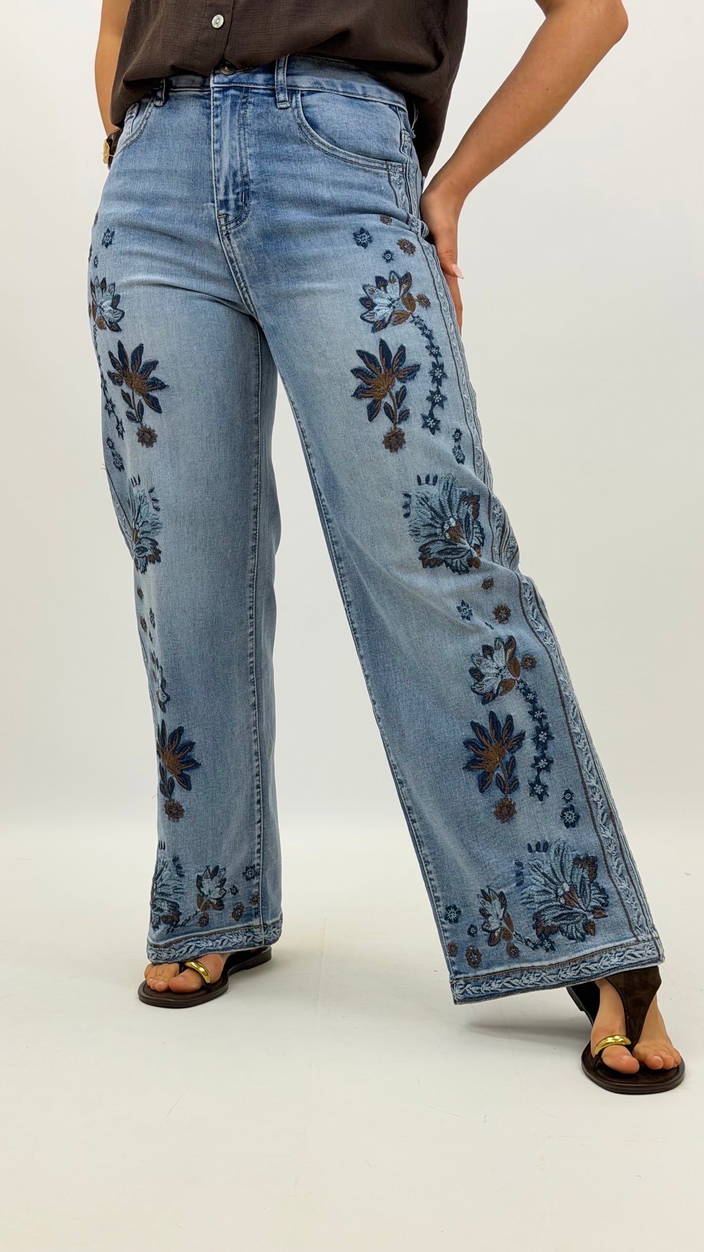 Calças ganga com bordado floral tons azul e castanho