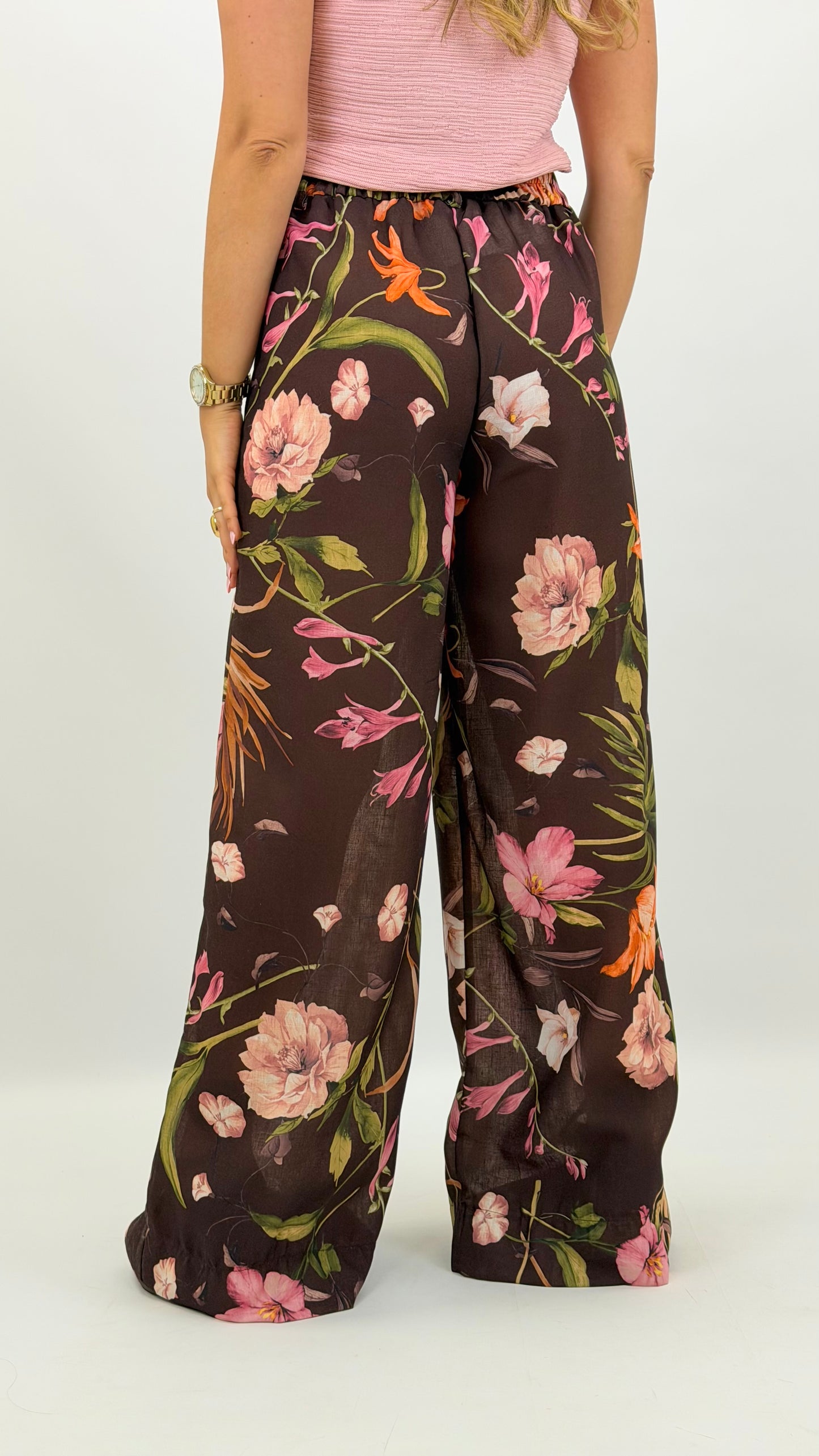 Pantalona castanha com estampado floral tons verde, laranja e rosa
